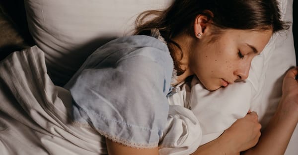 Жінка спокійно спить на білій подушці вночі